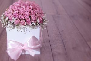 Un pot de rose avec un noeud en forme de cadeau